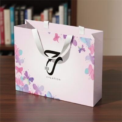 Printed ribbon handle paper bag with butterfly design and white satin handles for retail gift packaging